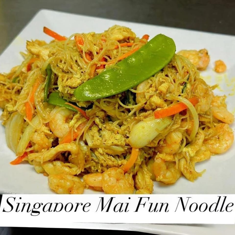Singapore Mai Fun Noodle dish with shrimp, chicken, vegetables, and a snow pea pod.