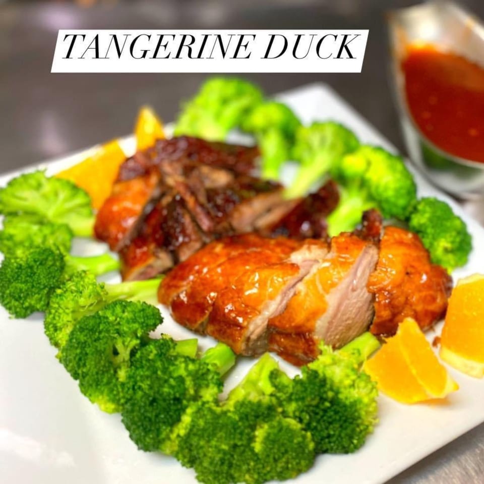 Asian Bistro's Tangerine Duck, sliced and served with broccoli florets and orange wedges.